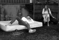 a man laying on a mattress next to a woman