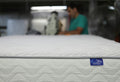 a man is working on a mattress in a warehouse