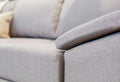 A close-up of a light grey fabric sofa.