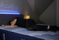 Person sleeping on their side on a mattress.