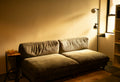 A comfortable sofa bathed in warm lamp light.